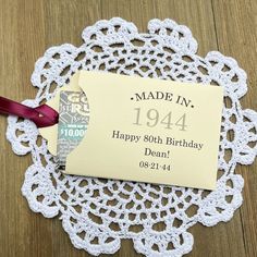 a happy birthday tag on a doily with a red ribbon around it that says made in 1994