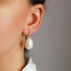 These Ceramic Pearl Earrings make a statement with their elegant, teardrop dangle and luxurious gold filled finish. Perfect for adding a touch of sophistication and class to an everyday look, they'll become your new go-to accessory. Dare to be bold and stylish!• Sold in pairs• Available in: High Quality Solid 925 Sterling Silver, Gold filled 12K and Rose gold filled 12K• Pearl drop size: 2cm x 1.5cm• Wire Thickness - 1mm (18gauge)• Length of the earrings: 3cm Chic Silver Teardrop Pearl Earrings, Pear-shaped Hoop Earrings For Gifts, Everyday Minimalist Pearl Drop Teardrop Earrings, Elegant Sterling Silver Teardrop Earrings For Everyday, Modern Pear-shaped Earrings For Wedding, Minimalist Teardrop Earrings For Party, Pearl Drop Teardrop Pendant Earrings As Gift, Pearl Drop Teardrop Pendant Earrings For Gift, Minimalist Pearl Drop Teardrop Earrings