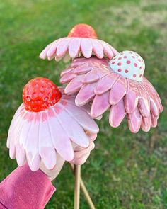 two pink flowers with strawberries on them are in the shape of ladybugs