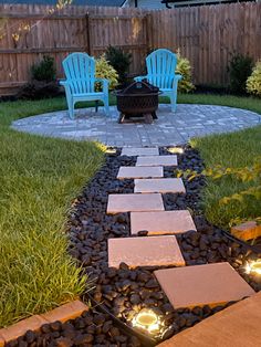 a patio with chairs and fire pit in the middle of it, surrounded by grass