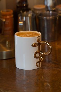 a white coffee mug sitting on top of a wooden table