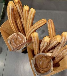 two boxes filled with churros and dipping sauce