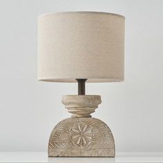 a lamp that is on top of a table with a light shade over it's head