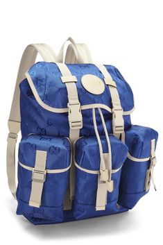 a blue and white backpack sitting on top of a white floor next to another bag