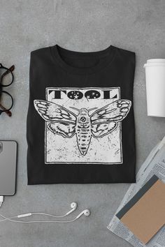 Tool Band Shirt|Tool Band Tour 2023 Concert Outfit Ticket Merch Sticker Creed Band Rage Against the Machine Unisex Jersey Short Sleeve Tee This classic unisex jersey short sleeve tee fits like a well-loved favorite. Soft cotton and quality print make users fall in love with it over and over again. These t-shirts have-ribbed knit collars to bolster shaping. The shoulders have taping for better fit over time. Dual side seams hold the garment's shape for longer.  .: 100% Airlume combed and ringspun cotton (fiber content may vary for different colors) .: Light fabric (4.2 oz/yd² (142 g/m .: Retail fit .: Tear away label .: Runs true to size Band Shirt Design Ideas, Band Tshirt Design Ideas, Tool The Band, Band Shirt Outfits, Tool Concert, Creed Band, Band Merch Ideas, Band Shirt Ideas, Merch Inspiration