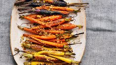 roasted carrots with herbs and seasoning on a white platter, ready to be eaten