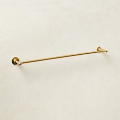 a gold colored towel bar on a white wall