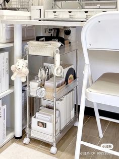 a white desk and chair with various items on the shelf in front of it,