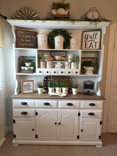 a white hutch filled with lots of plants and potted plants on top of it