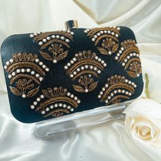 This stunning black clutch with it's beautiful antique gold embroidery, is the perfect compliment to any look! Size: 8×4 inches Shoulder strap included.