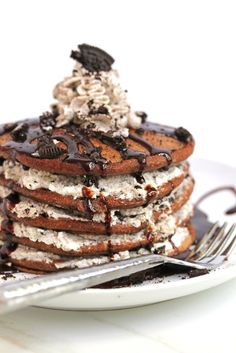 a stack of pancakes covered in ice cream and chocolate