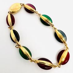 Beautiful Vintage Signed SWAROVSKI Multicolor Bezel Set Glass Disc Bracelet. Gold plated metal with multicolored jewel tone glass discs. Signed on clasp. In excellent vintage condition with minimal age appropriate wear. Measures 3/8 inch wide and is 8 inches long. Secure slide/box clasp Elegant Multicolor Metal Bracelet, Elegant Multicolor Metal Bracelets, Metal Bracelets With Multicolor Jeweled Details, Modern Multicolor Glass Jewelry, Retro Multicolor Bracelet Jewelry, Retro Multicolor Metal Bracelets, Vintage Gold Glass Bracelets, Slide Box, Disc Bracelet