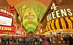 people are standing in the middle of a mall with neon signs on it's walls