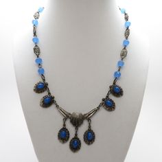 "Vintage Art Deco Blue Glass Necklace with Cabochon Fringe Center Drops Pretty 17\" White Metal and Blue Glass Fringe Necklace. It has fourteen 6.8mm faceted stepped topped art deco beads spaced between 12.7mm x 6.6mm dotted links. To top it off, it has five oval cabochon (7.4mm x 5.25mm) blue glass stones in a fringe pattern that hangs app. 1 1/2\". The blue is very similar to blue chalcedony in an aquamarine opaque color. Item #: NVCJ108 Style: Art Deco Metal: White Base Metal Condition: Very Blue Art Deco Necklace For Formal Occasions, Vintage Blue Czech Glass Necklace, Formal Blue Cabochon Necklace, Blue Art Deco Jewelry For Jewelry Making, Blue Vintage Cabochon Jewelry, Vintage Blue Cabochon Jewelry, Victorian Blue Jewelry For Jewelry Making, Antique Blue Metal Jewelry, Blue Cabochon Metal Jewelry