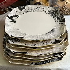 a stack of black and white plates sitting on top of a table