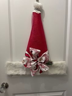 a red christmas hat hanging on the front door