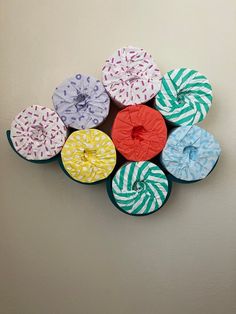 six donuts are arranged in the shape of a flower on a white wall with green and blue stripes