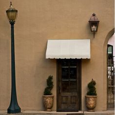 a lamp post sitting next to a building with a white awning on it's side