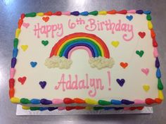 a birthday cake decorated with rainbows and hearts