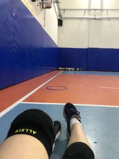 a person with their feet on the ground in an indoor basketball court while wearing black and white socks