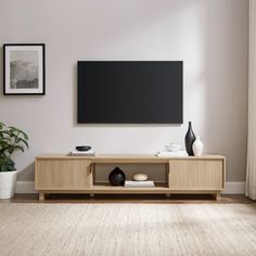 a flat screen tv mounted to the side of a wooden entertainment center in a living room