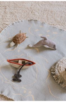 various sea animals on a rug in a living room or playroom, including a turtle, a dolphin, and a giraffe