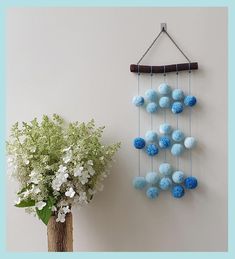 a vase filled with flowers next to a wind chime