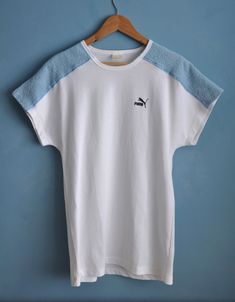 Vintage white and baby blue PUMA sports top, from the 1980s Summer 80s PUMA top with dolman short sleeves and long straight shape. The top features light blue terry cloth pieces on the shoulders, the rest is white! Has the brand's logo on the front Material - cotton and polyester, fabric is thick, not lightweight! Size - L Measurements (taken while top is lying flat, double armpit to armpit): Shoulders (undefined), measured from one sleeve's end to the other - 28.5 inches / 72.4 cm Armpit to Arm 90s Sports T-shirt For Summer, 90s Style White Short Sleeve T-shirt, White Retro T-shirt For Loungewear, White Sporty Top For Summer, Sporty White Top For Summer, Retro Sports T-shirt For Summer, White Short Sleeve T-shirt With 90s Style, White Short Sleeve T-shirt 90s Style, 90s Summer Sports T-shirt