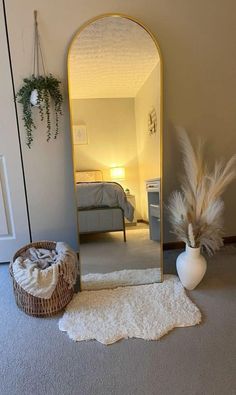 a large mirror sitting on top of a floor next to a basket