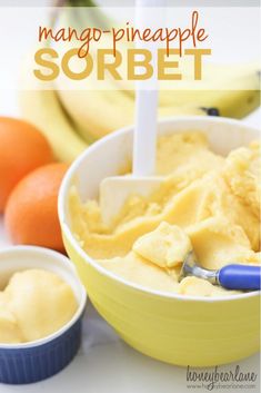 mango pineapple sorbet in a yellow bowl next to oranges and bananas