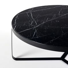 a black marble coffee table sitting on top of a white floor