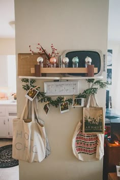 two bags hanging on the wall with pictures and photos attached to them in front of a refrigerator