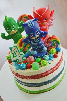 a birthday cake decorated with toy figures and candies