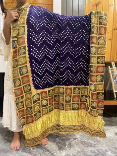 A Beautiful Gaji silk dupatta with the combination of two different crafts Bandhani and Ajrakh. Bandhani is a traditional form of tie-dye native to Gujarat and Rajasthan. It is a highly skilled technique where the fabric is elaborately tied & dipped in dyes and threads are removed leaving behind tiny circles characteristic of Bandhani. Ajrakh derived from the Persian to mean Indigo, a color hard to miss among the geometric and floral patterns of Ajrakh work. Ajrakh is a block-printing technique Blue Bandhani Print Dupatta For Festival, Bollywood Block Print Dupatta For Navratri, Navratri Bollywood Block Print Dupatta, Festival Traditional Wear With Bandhani Print, Chanderi Traditional Wear With Bandhani Print For Festivals, Festival Chanderi Traditional Wear With Bandhani Print, Festival Chanderi Bandhani Traditional Wear, Bohemian Bandhani Print Dupatta For Traditional Ceremonies, Bollywood Style Block Print Dupatta