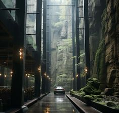 a car is parked in the middle of an indoor area with tall rocks and plants