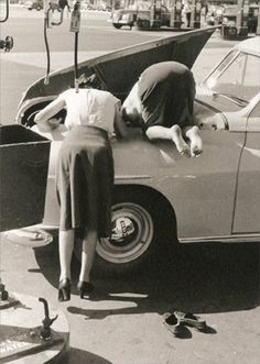 an old photo of two people leaning on the hood of a car with it's trunk open