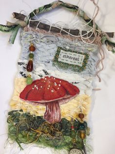 a painting of a red mushroom on the side of a wall hanging from a rope