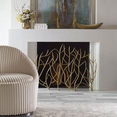 a white chair sitting in front of a fire place next to a painting on the wall