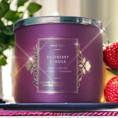 raspberry mimosa candle next to strawberries