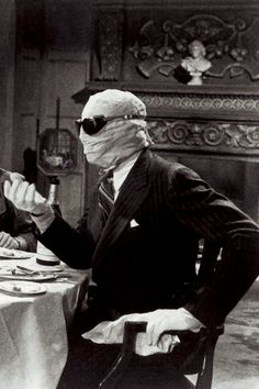 a man in a mask sitting at a table