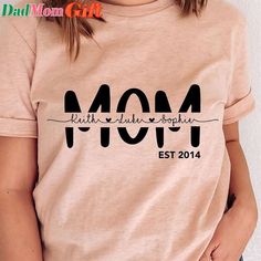 a woman wearing a t - shirt that says mom est 2014 on it and has her hands in her pockets