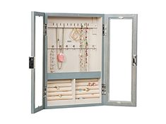 an open jewelry cabinet with several necklaces and rings on it's doors,