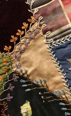 several different colored pieces of fabric on top of each other, including one with an embroidered design