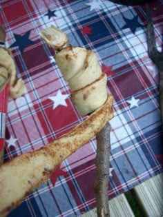 a close up of a piece of food on a stick with an american flag in the background