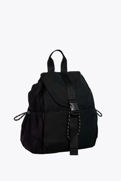 a black backpack with straps on the front and side pockets, sitting against a white background