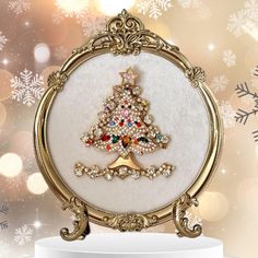 a christmas ornament with a gold frame and a small tree on the front