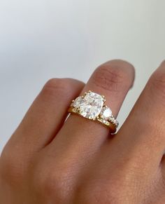 a woman's hand with a ring on it and a diamond in the middle