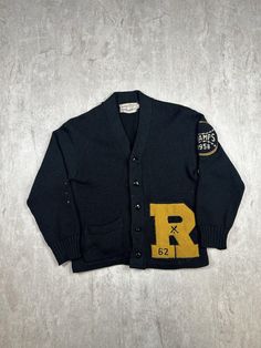 This Vintage 50s Roosevelt High School Cardigan Sweater, in men's size 36, is crafted from luxurious black wool and showcases timeless, classic style. With its retro varsity design, it's a unique piece of history perfect for collectors or those who appreciate vintage school apparel. Please refer to the provided pictures for a detailed view of the condition and measurements of this item. We strive to present our pieces as accurately as possible, ensuring you have a clear understanding of their fi Vintage College Sweater For Winter, Vintage Sweater For College In Winter, Vintage Winter Sweater For College, Vintage Black Sweater For Fall, Vintage Black Fitted Sweater, Vintage Long Sleeve Wool Varsity Jacket, Vintage Winter Workwear Cardigan, Vintage College Sweater For Fall, Vintage Sweater For College In Fall