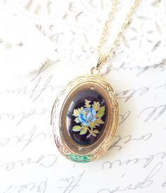 "A gorgeous gold plated photo locket adorned with a lovely vintage black glass limoges with blue rose and gold and green leaves dangles so pretty from a 16k gold plated link chain with lobster clasp. Locket has a lovely floral etched pattern Total length of chain measures 18\" Locket measures 23x30mm Cameo measures 18x13mm Locket is high quality and nickel free Your purchase will come beautifully wrapped ready for gift giving" Elegant Enamel Cameo Jewelry, Vintage Enamel Oval Pendant Jewelry, Vintage Blue Keepsake Jewelry, Heirloom Black Enamel Jewelry For Gift, Heirloom Black Enamel Jewelry As Gift, Vintage Blue Locket Necklace For Gift, Vintage Rose Gold Enamel Jewelry, Vintage Black Enamel Jewelry For Wedding, Vintage Necklace With Black Enamel For Gift