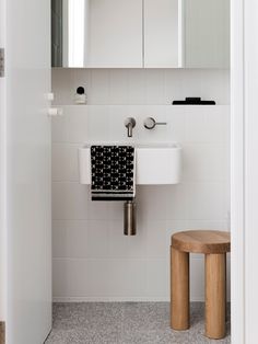 a bathroom with a sink, mirror and stool